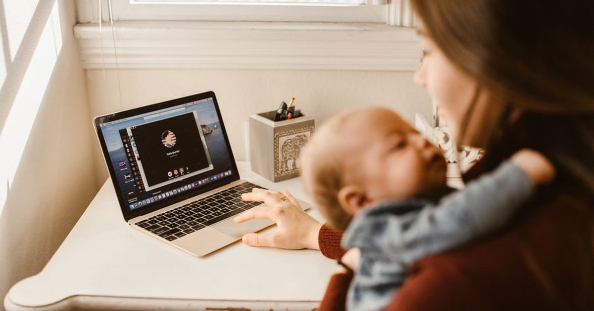 mother holding baby working laptop